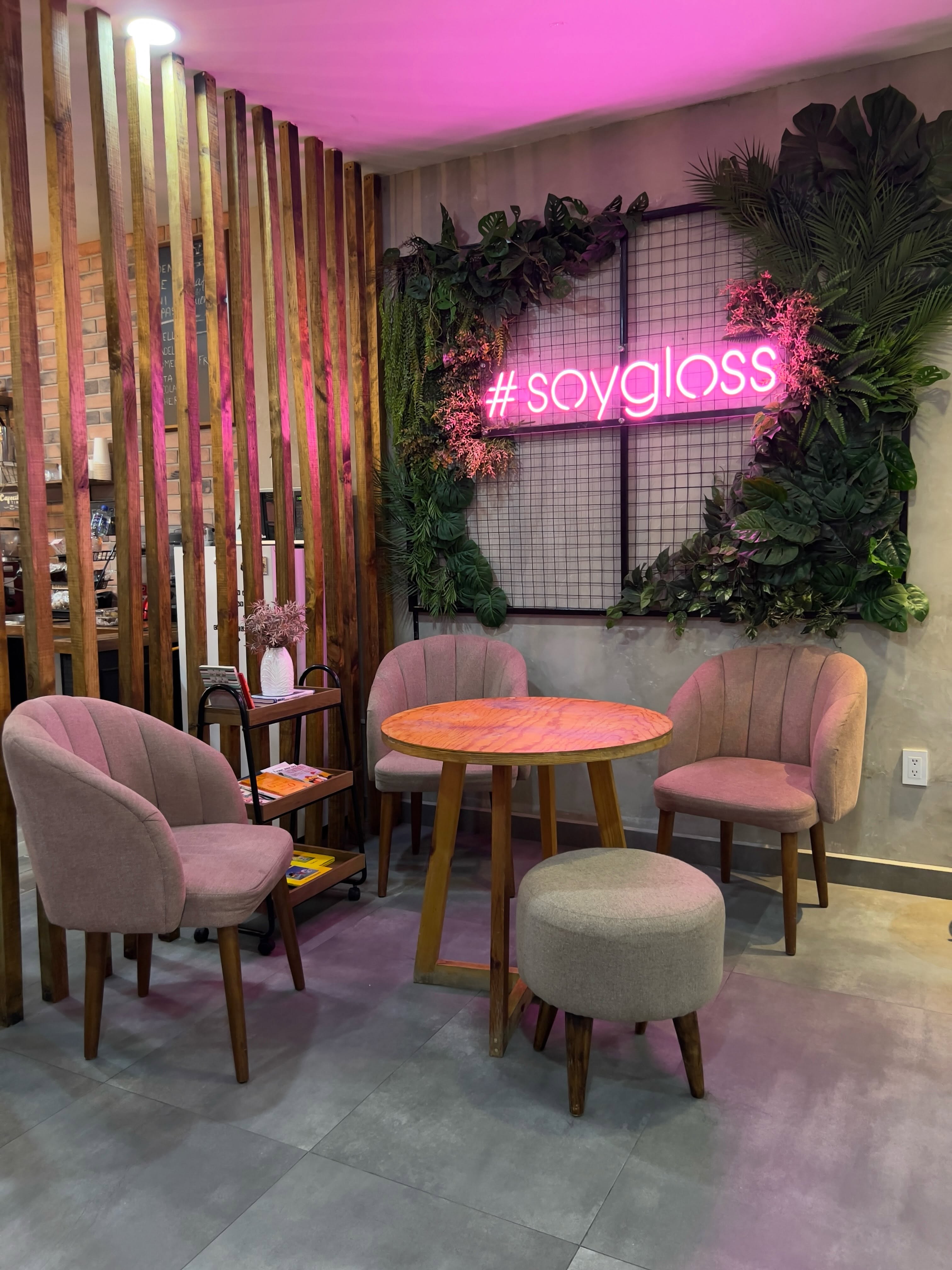 Clienta trabajando en laptop mientras recibe estilizado en GLOSS Beauty Salon y toma café